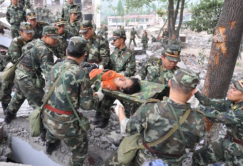 5月13日,武警戰(zhàn)士在搶救受災(zāi)學(xué)生。記者從四川省綿陽(yáng)市抗震救災(zāi)指揮部了解到,受災(zāi)特別嚴(yán)重的北川縣老縣城80%、新縣城60%以上建筑物垮塌,縣城周邊發(fā)生大面積山體滑坡。 新華社記者 焦衛(wèi)平 攝