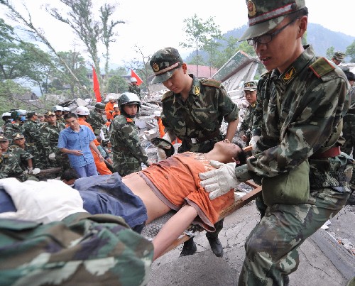 5月13日,救援人員在搶救受災(zāi)學(xué)生。記者從四川省綿陽(yáng)市抗震救災(zāi)指揮部了解到,受災(zāi)特別嚴(yán)重的北川縣老縣城80%、新縣城60%以上建筑物垮塌,縣城周邊發(fā)生大面積山體滑坡。 新華社記者 焦衛(wèi)平 攝