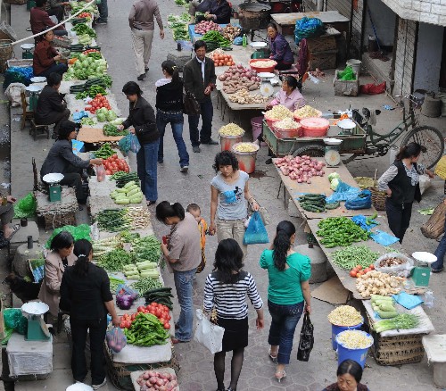 5月13日,甘肅省隴南市武都區(qū)的居民在菜市場買菜。 甘肅省隴南市努力做好各項(xiàng)生活必需品供應(yīng),確保因汶川地震而受災(zāi)的群眾生活不出問題。有關(guān)部門積極組織貨源,保證市場物價(jià)不出大的波動(dòng)。 新華社記者 韓傳號(hào) 攝