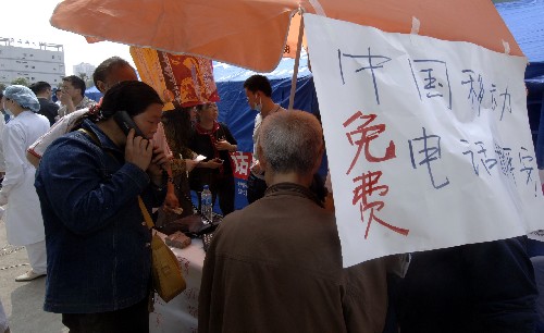 5月15日上午,災(zāi)民在綿陽市區(qū)通過免費(fèi)電話與親人聯(lián)系。 目前,中國移動公司已經(jīng)在四川省境內(nèi)設(shè)立了2100多個移動通信救災(zāi)及便民服務(wù)點(diǎn),為受災(zāi)群眾提供免費(fèi)應(yīng)急通話、長途電話“報(bào)平安”、手機(jī)充電等服務(wù)。 新華社記者 趙穎全 攝