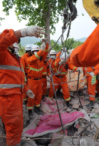 5月15日,搜救人員在緊張工作。 自14日下午開始,來自遼寧的消防官兵和當(dāng)?shù)氐拿癖鴳?yīng)急小分隊(duì)在四川青川縣木魚中學(xué)倒塌的宿舍廢墟上盡全力搜救被困學(xué)生。 新華社記者 陶明 攝