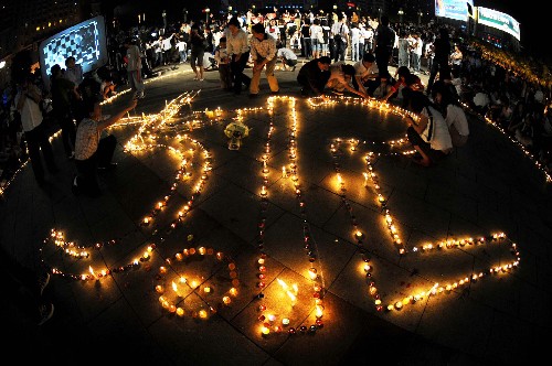 5月15日,長(zhǎng)沙市市民將蠟燭擺成“5·12”的形狀。 當(dāng)日,湖南省慈善總會(huì)等機(jī)構(gòu)在長(zhǎng)沙市五一廣場(chǎng)發(fā)起抗震救災(zāi)燭光祈福募捐晚會(huì)。廣大市民在廣場(chǎng)上現(xiàn)場(chǎng)捐款,并將蠟燭拼成“5·12”形狀,悼念在地震中死去的同胞。 新華社記者 李尕 攝