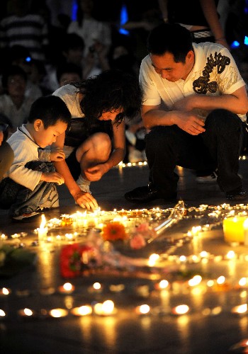 5月15日,長(zhǎng)沙市的一家三口正在點(diǎn)燃蠟燭,悼念在地震中死去的同胞。 當(dāng)日,湖南省慈善總會(huì)等機(jī)構(gòu)在長(zhǎng)沙市五一廣場(chǎng)發(fā)起抗震救災(zāi)燭光祈福募捐晚會(huì)。廣大市民在廣場(chǎng)上現(xiàn)場(chǎng)捐款,并將蠟燭拼成“5·12”形狀,悼念在地震中死去的同胞。 新華社記者 李尕 攝