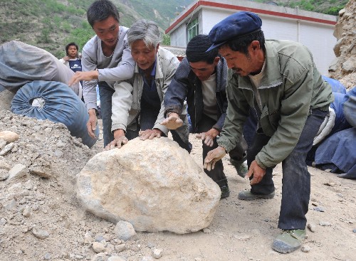 5月15日,甘肅省隴南市文縣鐵樓藏族鄉(xiāng)麥貢山村村民在清理村口道路上的落石。 受汶川地震影響,甘肅省隴南市文縣鐵樓藏族鄉(xiāng)2468戶群眾全部受災(zāi),其中360余戶住房倒塌,968戶住房成為危房,其余房屋出現(xiàn)裂縫、傾斜等不同程度損壞。目前抗震救災(zāi)工作正在緊張進(jìn)行。 新華社記者 韓傳號 攝