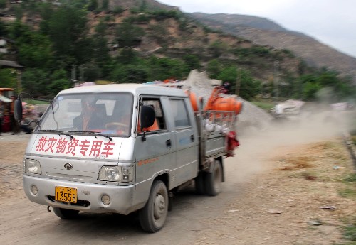 5月15日,運送救災(zāi)物資的車輛行駛在甘肅省隴南市文縣鐵樓藏族鄉(xiāng)的鄉(xiāng)村道路上。 受汶川地震影響,甘肅省隴南市文縣鐵樓藏族鄉(xiāng)2468戶群眾全部受災(zāi),其中360余戶住房倒塌,968戶住房成為危房,其余房屋出現(xiàn)裂縫、傾斜等不同程度損壞。目前抗震救災(zāi)工作正在緊張進(jìn)行。 新華社記者 韓傳號 攝
