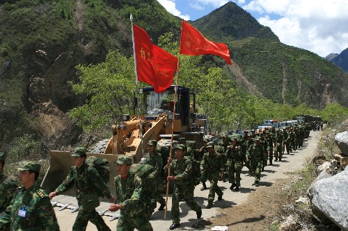 5月14日,解放軍官兵向茂縣災(zāi)區(qū)挺進(jìn)。 成都軍區(qū)駐渝紅軍師某團(tuán)部隊(duì)官兵用直升機(jī)在四川省茂縣空投食品和醫(yī)療藥品后,大部隊(duì)向?yàn)?zāi)區(qū)緊急推進(jìn),疏散游客,清理路障,搶運(yùn)傷員。 新華社發(fā)(高效文 攝)