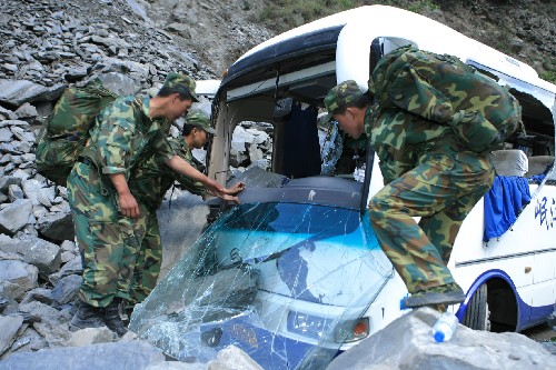 5月14日,解放軍官兵在茂縣災(zāi)區(qū)清理被巨石砸壞的車(chē)輛,開(kāi)辟道路。 成都軍區(qū)駐渝紅軍師某團(tuán)部隊(duì)官兵用直升機(jī)在四川省茂縣空投食品和醫(yī)療藥品后,大部隊(duì)向?yàn)?zāi)區(qū)緊急推進(jìn),疏散游客,清理路障,搶運(yùn)傷員。 新華社發(fā)(高效文 攝)