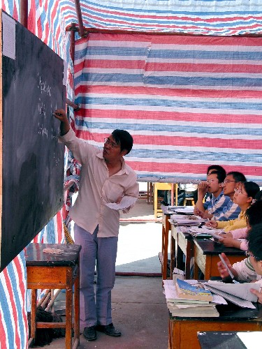 5月16日,隴南市一中教師在帳篷教室內(nèi)授課。當(dāng)日,受汶川地震嚴(yán)重影響的甘肅省隴南市的高三年級學(xué)生在帳篷中復(fù)課。與此同時,隴南市的中小學(xué)也在抓緊搭建簡易帳篷,為全面復(fù)課做好準(zhǔn)備。 新華社記者 連振祥 攝