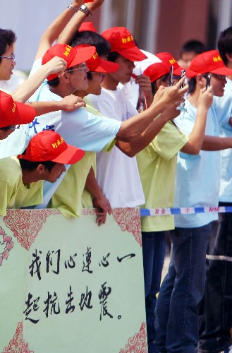 5月16日,當?shù)厝罕娫谟^看圣火傳遞時打出標語支持地震災區(qū)人民。當日,北京奧運圣火傳遞活動在江西南昌舉行。 新華社記者 邢廣利 攝