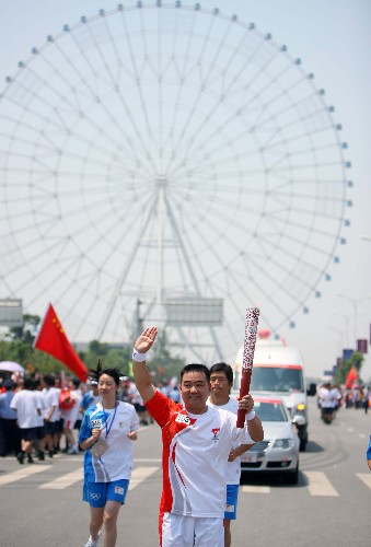 5月16日,奧運火炬手手持火炬?zhèn)鬟f。當日,北京奧運圣火傳遞活動在江西南昌舉行。 新華社記者 邢廣利 攝