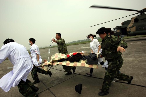 5月16日,救援人員在成都某軍用機(jī)場(chǎng)轉(zhuǎn)運(yùn)汶川災(zāi)區(qū)傷員。 新華社記者 王建民 攝
