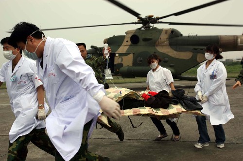 5月16日,救援人員在成都某軍用機(jī)場(chǎng)轉(zhuǎn)運(yùn)汶川災(zāi)區(qū)傷員。 新華社記者 王建民 攝