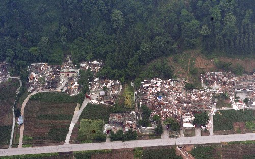 這是公路邊一個(gè)被震毀的村莊(5月16日攝)。 當(dāng)日,新華社記者搭乘軍用直升機(jī),沿著四川省綿竹市、什邡市之間的石亭江,航拍了兩市農(nóng)村的災(zāi)情。 新華社記者 苑堅(jiān) 攝