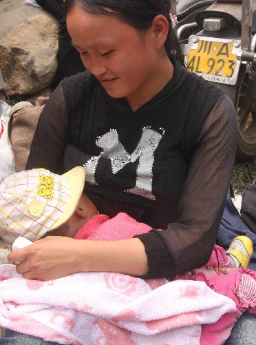 5月16日,汶川縣映秀鎮(zhèn)的一位婦女在被轉(zhuǎn)移到安全地帶后放心地給孩子喂奶。解放軍、武警官兵不斷往返于通往汶川縣映秀鎮(zhèn)的水上“生命之路”,送去搶險(xiǎn)人員和救災(zāi)物資,接出災(zāi)民。 新華社發(fā)(郭國(guó)權(quán) 攝)