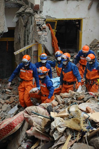 5月17日,日本搜救人員將遇難者遺體抬出廢墟。 當(dāng)日7時25分,日本救援人員歷經(jīng)16個小時的搜救,在四川青川縣喬莊鎮(zhèn)一處倒塌的六層樓房廢墟中挖出兩具遇難者遺體。 新華社記者 李濤 攝