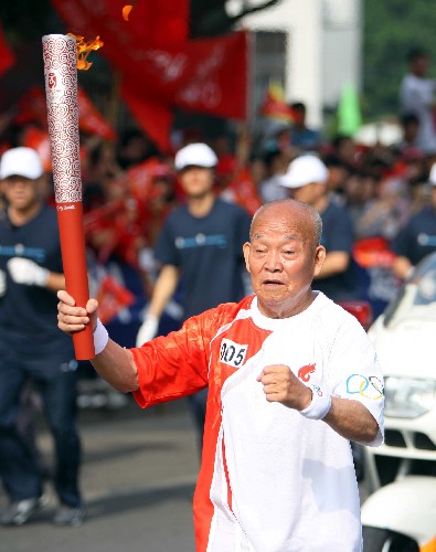 5月17日,火炬手鄧洪如進(jìn)行傳遞。當(dāng)日,北京奧運(yùn)會圣火在浙江溫州傳遞。 新華社記者 安治平 攝