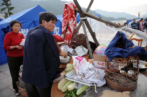 5月14日,一位災(zāi)民在德陽市漢旺廣場上做飯。盡管汶川地震給四川當?shù)鼐用竦纳钤斐珊艽笃茐?,許多人被迫居住在條件簡陋的臨時居所中,但生活依舊在繼續(xù)。 新華社記者 王建華 攝