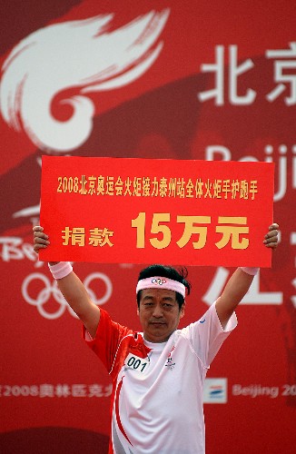 5月26日,第一棒火炬手張云泉在起跑儀式上代表泰州站全體火炬手、護跑手向四川地震災區(qū)捐款。當日,北京奧運會圣火在江蘇泰州傳遞。 新華社記者 韓瑜慶 攝