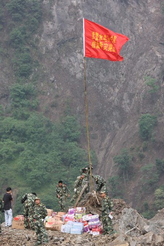 5月26日,武警水電部隊官兵把紅旗豎起在唐家山堰塞湖搶險前沿。連日來,唐家山堰塞湖水位上漲,嚴(yán)重威脅災(zāi)區(qū)群眾及抗震救援部隊和搶險人員的安全。前期徒步進(jìn)入這里進(jìn)行搶險的解放軍和武警部隊官兵,因缺少食品和飲用水,生活非常艱苦。 5月26日,濟(jì)南軍區(qū)某陸航團(tuán)的直升機(jī)裝載食品、物資和燃料,運送至唐家山堰塞湖壩上。 新華社記者 李剛 攝