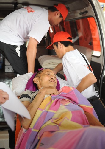 5月27日,志愿者在石家莊火車站將一名傷員抬上救護(hù)車。 當(dāng)日,首批到河北接受治療的77名四川汶川大地震受傷傷員由四川廣元乘坐專列抵達(dá)石家莊。這些傷員將被安置在石家莊市各大醫(yī)院接受治療。 新華社記者 楊世堯 攝