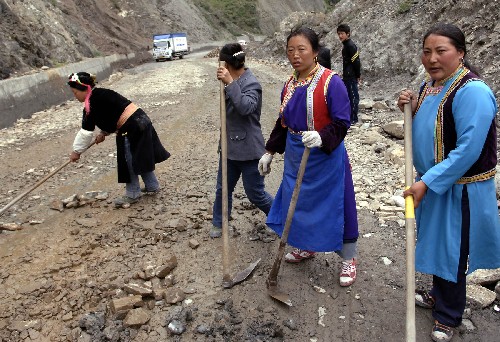 5月27日,四川省寶興縣磽磧藏族鄉(xiāng)的藏族同胞在維修塌方路段。 汶川地震以后,從成都繞經(jīng)雅安、馬爾康至汶川的公路成為通往汶川的“生命通道”。沿線的藏族群眾自發(fā)行動起來護路排險,確保道路暢通無阻。 新華社記者 李健 攝