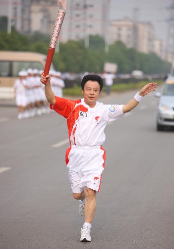 6月5日,火炬手余愛國手持火炬?zhèn)鬟f。當日,北京奧運圣火在湖南湘潭傳遞。 新華社記者 邢廣利 攝