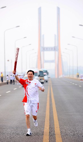 6月5日,火炬手高希明手持火炬?zhèn)鬟f。當日,北京奧運圣火在湖南湘潭傳遞。 新華社記者 邢廣利 攝