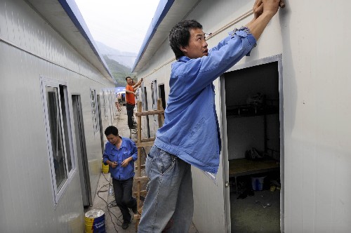 6月4日,一名電工正在為活動(dòng)板房安置區(qū)安裝路燈。由重慶市援建的汶川縣漩口鎮(zhèn)圣音寺村首批活動(dòng)板房即將投入使用。 據(jù)了解,該活動(dòng)板房安置區(qū)將優(yōu)先安排孤老、婦女兒童居住。 新華社記者 李紫恒 攝