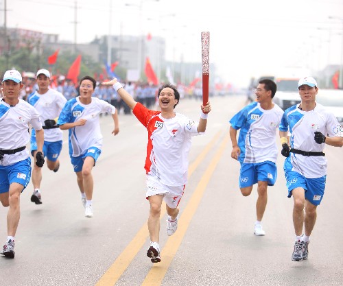6月5日,火炬手湯國強手持火炬?zhèn)鬟f。當日,北京奧運圣火在湖南湘潭傳遞。 新華社記者 邢廣利 攝
