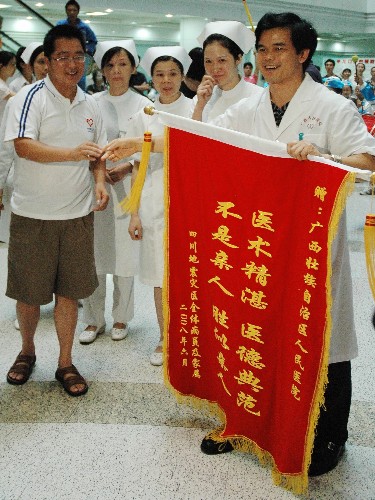 月15日,廣西壯族自治區(qū)人民醫(yī)院代表接受病人家屬贈(zèng)送的錦旗。 新華社記者 向志強(qiáng) 攝