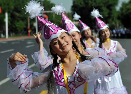 6月17日,一些中學(xué)生在表演柯?tīng)柨俗巫逦璧笟g迎奧運(yùn)圣火的到來(lái)。當(dāng)日,北京奧運(yùn)圣火在新疆烏魯木齊傳遞。 新華社記者 趙戈 攝