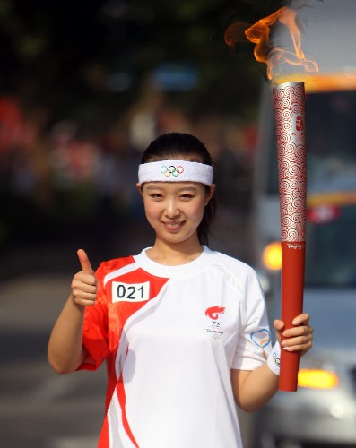 6月25日,奧運(yùn)火炬手李喆手持火炬?zhèn)鬟f。當(dāng)日,北京奧運(yùn)圣火在山西運(yùn)城傳遞。 新華社記者 邢廣利 攝