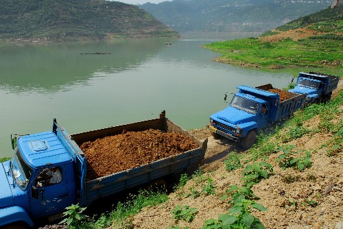 6月24日,運(yùn)土車輛行駛在秭歸縣郭家壩鎮(zhèn)的鄉(xiāng)村公路上。 新華社發(fā)(鄭家裕 攝)