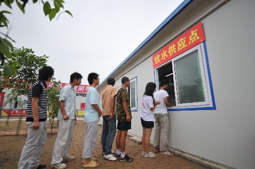 7月3日,在地震災(zāi)區(qū)四川安縣中學(xué)考點,考生在考試前于考場附近的飲水供應(yīng)點領(lǐng)水。 當(dāng)日,備受關(guān)注的川甘12萬地震災(zāi)區(qū)考生順利步入高考考場,考試時間是7月3日、4日、5日。其中,大約有78%的考生在本地活動板房參加考試,15%的考生在本地經(jīng)過抗震鑒定合格的教室里參加考試,極少部分考生到異地參加考試。 新華社記者 聶建江 攝