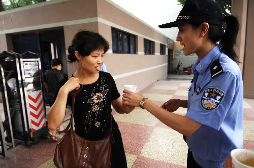 7月3日,在四川都江堰市抗震救災(zāi)的哈爾濱特警為考點外的家長送上綠豆湯。 新華社記者 章磊 攝