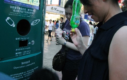 7月5日,行人準(zhǔn)備將飲料瓶投入飲料容器自動(dòng)回收機(jī)。 上海南京路步行街上新設(shè)的飲料容器自動(dòng)回收機(jī)深受市民和游客歡迎。這種回收機(jī)可有償回收空瓶空罐,既節(jié)約了資源,又有利于環(huán)保,游客們也樂(lè)于體驗(yàn)回收過(guò)程帶來(lái)的樂(lè)趣。 新華社發(fā)(蔣振雄 攝)
