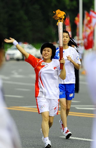 7月18日,火炬手花菊手持火炬進(jìn)行傳遞。當(dāng)日,北京奧運(yùn)圣火在遼寧省鞍山市傳遞。 新華社記者 任勇 攝