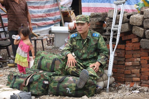 7月21日,在抗震救災(zāi)中受傷的解放軍戰(zhàn)士王寶紅在看守戰(zhàn)友的行囊,準(zhǔn)備撤離。當(dāng)日,在重災(zāi)區(qū)四川省綿竹市漢旺鎮(zhèn)抗震救災(zāi)兩個(gè)多月的空降兵某部2000余名官兵集結(jié)后準(zhǔn)備撤離,當(dāng)?shù)財(cái)?shù)千名群眾聞?dòng)嵹s來送別親人解放軍。 新華社記者 李剛 攝