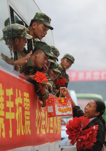 7月21日,四川省什邡市鎣華鎮(zhèn)一位婦女給撤離的解放軍官兵送來食品。當(dāng)日,在抗震救災(zāi)一線奮戰(zhàn)近兩個(gè)月的空軍某部1700多名官兵撤離四川省什邡市鎣華鎮(zhèn),數(shù)千名當(dāng)?shù)厝罕娐動(dòng)嵹s來送別親人解放軍。 新華社記者 江宏景 攝