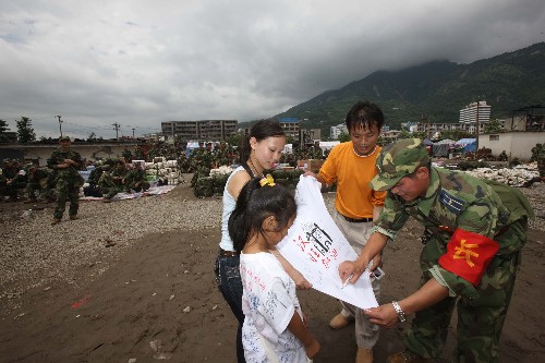 7月21日,空降兵某部軍官撤離前為小朋友簽名。當(dāng)日,在重災(zāi)區(qū)四川省綿竹市漢旺鎮(zhèn)抗震救災(zāi)兩個(gè)多月的空降兵某部2000余名官兵集結(jié)后準(zhǔn)備撤離,當(dāng)?shù)財(cái)?shù)千名群眾聞?dòng)嵹s來送別親人解放軍。 新華社記者 李剛 攝