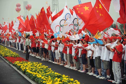 7月22日,觀眾為火炬?zhèn)鬟f加油。當(dāng)日,北京奧運(yùn)圣火在山東省泰安市傳遞。 新華社記者 范長(zhǎng)國(guó) 攝