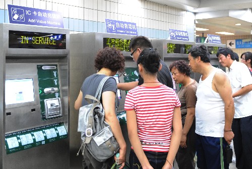 7月22日,乘客在天安門(mén)東站的自動(dòng)售票機(jī)前購(gòu)買車票。隨著北京奧運(yùn)會(huì)的臨近和機(jī)動(dòng)車單雙號(hào)限行規(guī)定的施行,更多的市民和游客選擇地鐵出行。 新華社記者 李勇 攝