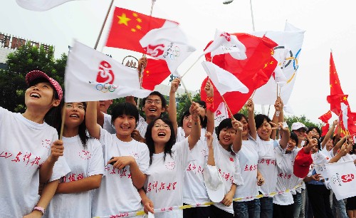 7月22日,學(xué)生們?cè)跒榛鹁鎮(zhèn)鬟f加油。當(dāng)日,北京奧運(yùn)圣火在山東省泰安市傳遞。 新華社記者 劉力航 攝