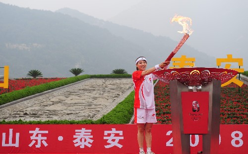 7月22日,火炬手畢文靜點(diǎn)燃圣火盆。當(dāng)日,北京奧運(yùn)圣火在山東省泰安市傳遞。 新華社記者 朱崢 攝