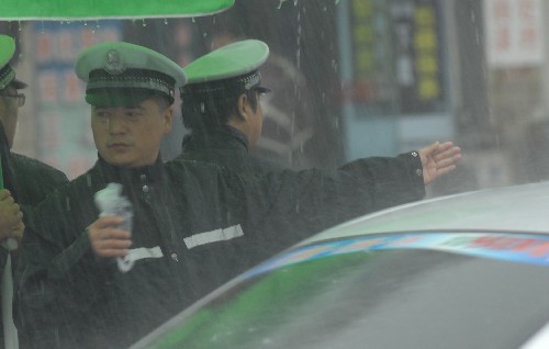 7月22日,襄樊市區(qū)積水嚴(yán)重,交警在大雨中指揮交通。 新華社發(fā)