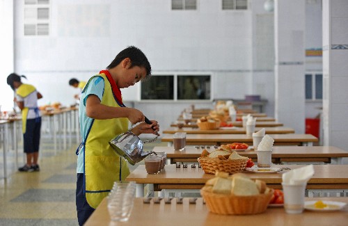 7月20日,在俄羅斯圖阿普謝市“小鷹”全俄兒童中心的食堂,來自四川地震災(zāi)區(qū)的學(xué)生為同學(xué)準(zhǔn)備早餐。學(xué)生們每人都要輪流做食堂的值日生,為其他人服務(wù)。 新華社記者 沈伯韓 攝