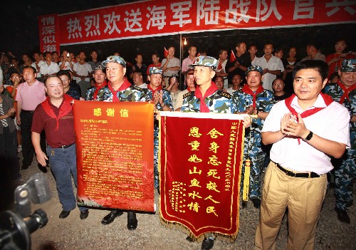 7月23日,災區(qū)群眾向海軍陸戰(zhàn)隊官兵贈送錦旗。 新華社記者 查春明 攝