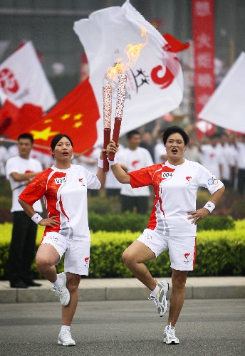 7月28日,火炬手張美瑛(右)與下一棒火炬手張峻英交接后合影。當(dāng)日,北京奧運(yùn)圣火在河南省安陽(yáng)市傳遞。 新華社記者 邢廣利 攝