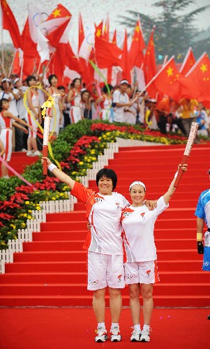 7月29日,第一棒火炬手李梅素(左)與下一棒火炬手袁淑梅在交接前展示火炬。當日,北京奧運圣火在河北省石家莊市傳遞。 新華社記者 楊世堯 攝