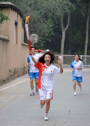 7月29日,火炬手王小節(jié)手持火炬?zhèn)鬟f。當日,北京奧運圣火在河北省石家莊市傳遞。 新華社記者 楊世堯 攝